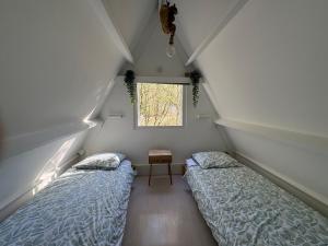 a attic room with two beds and a window at Sequoia Duo 2 chalets voisins, familles,amis,détente in Durbuy +51 photos