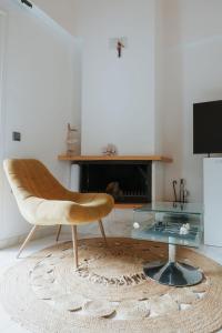 a living room with a chair and a glass table at Nafos Villa Stella in Levkákia