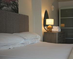 a bedroom with two beds and a lamp and a mirror at Cranwell Court in Aberystwyth