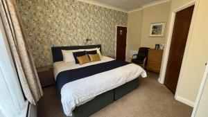 a bedroom with a large bed and a chair at The Coach House in Melbourne