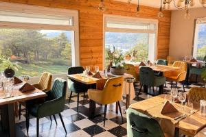 a restaurant with wooden walls and tables and windows at Logis Hotel Eden Lac in Savines