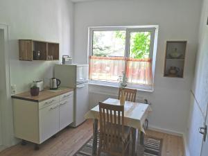 a small kitchen with a table and a window at Ferienwohnung 1 Nordsee Gulfhof Dornum - mit großem Garten in Roggenstede