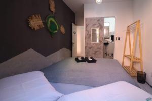 a bedroom with a bed with two shoes on it at Aloha Guest House in Fortaleza
