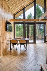 a room with a table and chairs and windows at Norway Cabins Sinaia Romantic Nordic Escape and Fire Pit in Sinaia