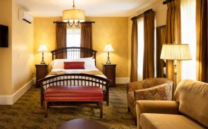 a bedroom with a bed and a chair and a couch at The Washington House Hotel & Restaurant in Sellersville