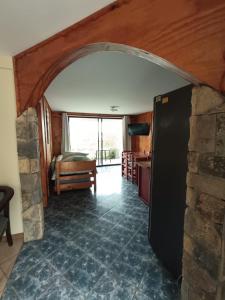 a living room with a black refrigerator and a stone wall at Strandvagen Maitencillo in Maitencillo
