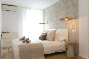 a bedroom with a white bed and a window at L’Ancora Suite in Jávea