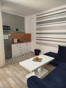 a living room with a white table and a kitchen at Mejdan II in Mostar