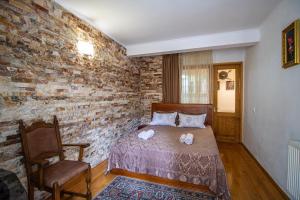 a bedroom with a bed and a brick wall at Cozy Apartment on Kostava in Tbilisi City +17 photos