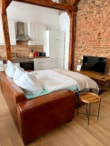 a bedroom with a large bed in a brick wall at Loft in der Innenstadt von Fulda, 60qm, privater Eingang in Fulda +10 photos