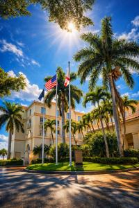 a building with palm trees in front of a street at Hilton Naples in Naples