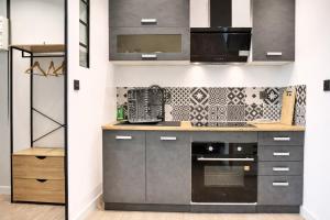 a kitchen with stainless steel appliances and a wall at Le 5 Place Carnot in Douai +9 photos