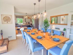 a dining room with a wooden table and blue chairs at Villa Serena in Mijas Costa
