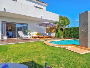 a backyard with a swimming pool and a house at Villa Serena in Mijas Costa