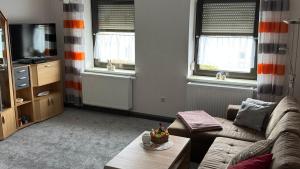 a living room with a couch and a tv at Ferienwohnung Irma in Malschwitz