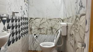 a bathroom with a toilet and a sink at swagatom Homestay in Jorhat
