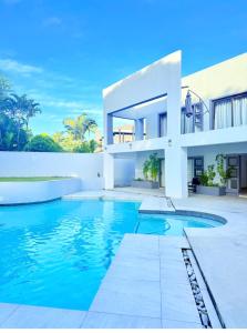 a large white house with a swimming pool at Golfview luxury apartment in Richards Bay