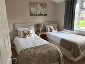 a bedroom with two beds and a window at par 3 in Wisbech +14 photos