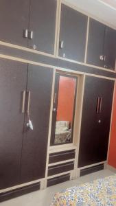 a bedroom with gray cabinets and a bed and a mirror at House in Mohali