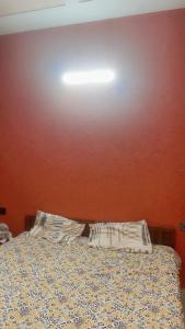 a bedroom with a bed and a red wall at House in Mohali