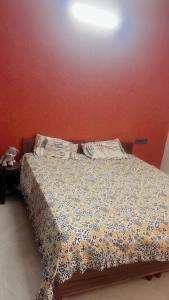 a bedroom with a bed with a floral comforter at House in Mohali