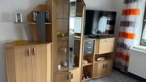 a wooden entertainment center with a flat screen tv at Ferienwohnung Irma in Malschwitz