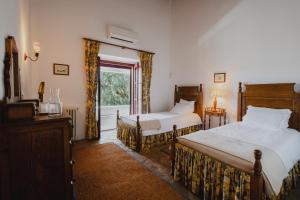 a bedroom with two beds and a window at Monte da Lapa in Arraiolos