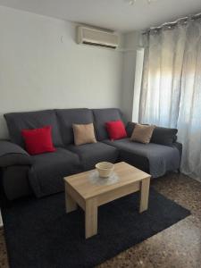 a living room with a blue couch with red pillows at Apartamento Dúplex vacacional in Burriana