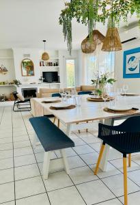 a dining room and living room with a table and chairs at Le Cottage de L&M in Sigean
