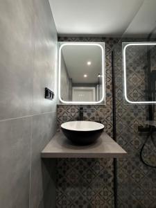 a bathroom with a bowl sink and a mirror at CentralPark Katowice in Katowice