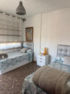 a bedroom with two beds and a white dresser at Apartamento Dúplex vacacional in Burriana