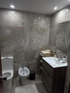 a bathroom with a toilet and a bidet and a sink at Apartamento Dúplex vacacional in Burriana