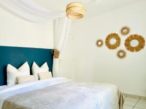 a bedroom with a white bed with a blue headboard at Le Cottage de L&M in Sigean +37 photos