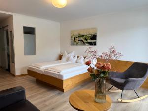 a bedroom with a bed and a table with a vase of flowers at Seehotel Lilly in Strobl