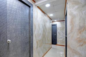 a walk in shower with a door in a room at Hotel O Jalan Regency in Kolkata