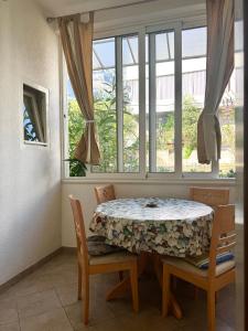 a dining room with a table and chairs and a window at Apartments Robert in Tučepi