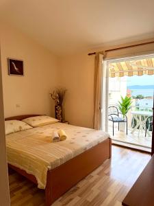 a bedroom with a bed and a balcony with a view at Apartments Robert in Tučepi