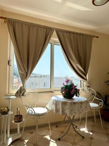 a room with a table and chairs in front of a window at Apartments Robert in Tučepi