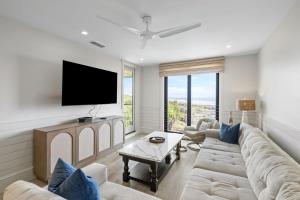 a living room with a couch and a flat screen tv at 2371 Shipwatch Villa by Akers Ellis Rentals in Kiawah Island