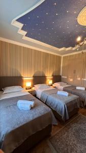 three beds in a room with a star ceiling at Guest House Melissa in Duisi