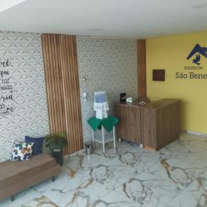 a hotel lobby with a desk and a chair in a room at Pousada São Benedito CP in Cachoeira Paulista