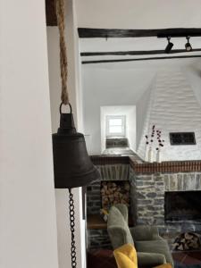 a living room with a fireplace and a black bell at Zur Klapperburg in Zell an der Mosel