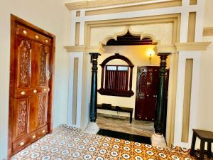 a bedroom with a bed and a large mirror at Chola Heritage Resort in Kāraikkudi