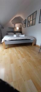 a bedroom with a bed and a wooden floor at Studio Arc en Ciel in Bouguenais