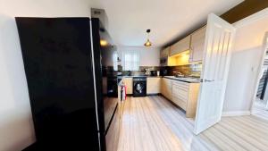 a kitchen with a black refrigerator in a room at Simply The Bay - Part of the The Bay Filey Holiday Village with pool, gym and direct beach access, pub, restaurant, tennis and meadows walks in Filey