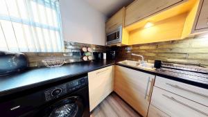 a kitchen with a black dishwasher and a sink at Simply The Bay - Part of the The Bay Filey Holiday Village with pool, gym and direct beach access, pub, restaurant, tennis and meadows walks in Filey