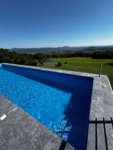 a large blue swimming pool with a view at Sumadijski ranc-Brvnara in Brestovac