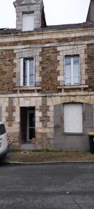 a brick building with two white garage doors on it at Studio Arc en Ciel in Bouguenais