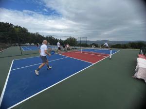 a group of people playing tennis on a tennis court at Sumadijski ranc-Brvnara in Brestovac