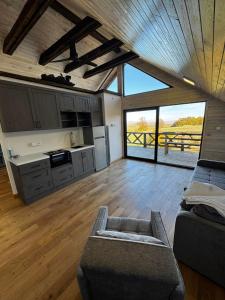 a living room with a couch and a kitchen at Sumadijski ranc-Brvnara in Brestovac